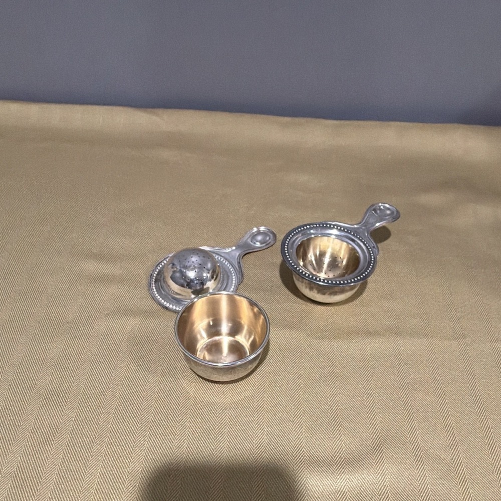 Vintage tea strainers with its matching drip stand.